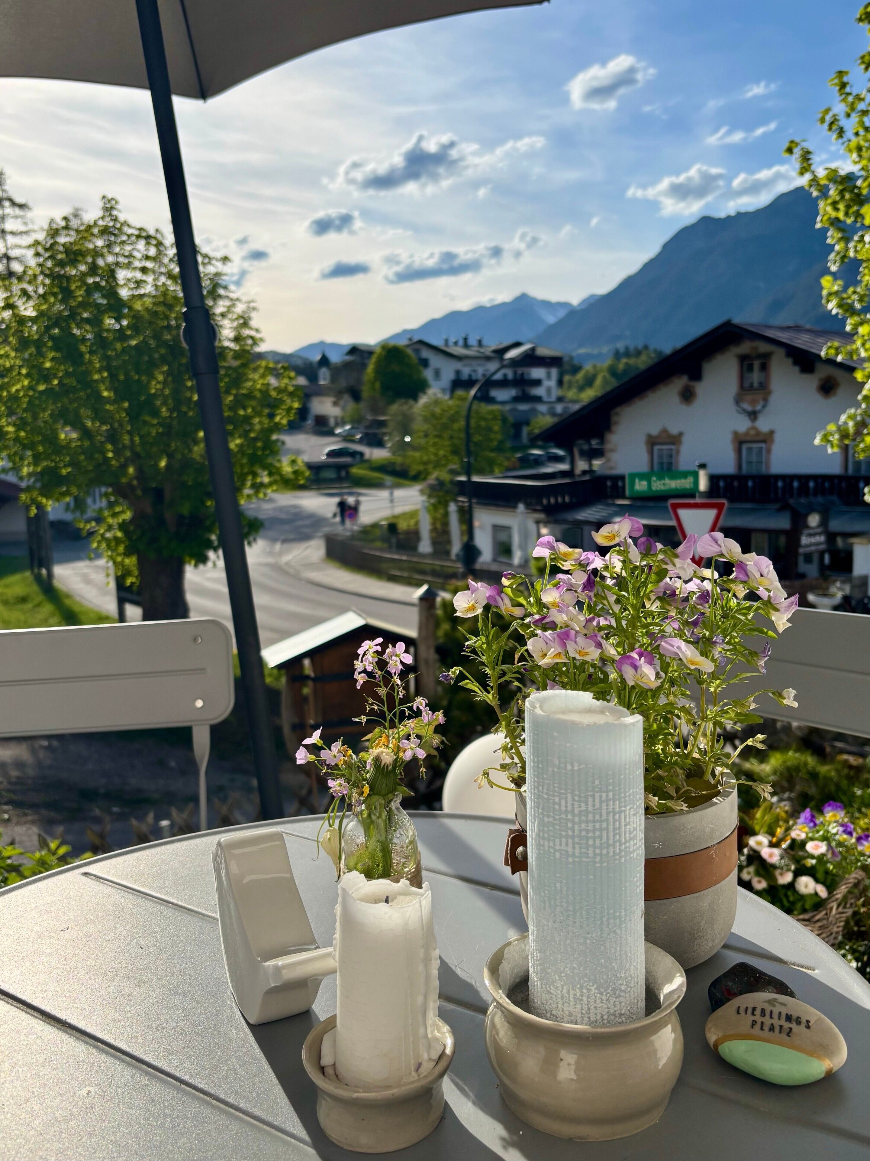 A table with a candle, a vase with flowers, and a sign reading 'LIEBLINGS PLATZ'.