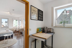A modern bedroom with a bed, bedside table, and a desk with chairs. - Holiday Apartment 'Hübsche Wohnung" with Balcony & Wi-Fi (Pforzheim)