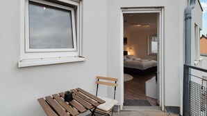 Une pièce avec un lit, un banc et une fenêtre.
