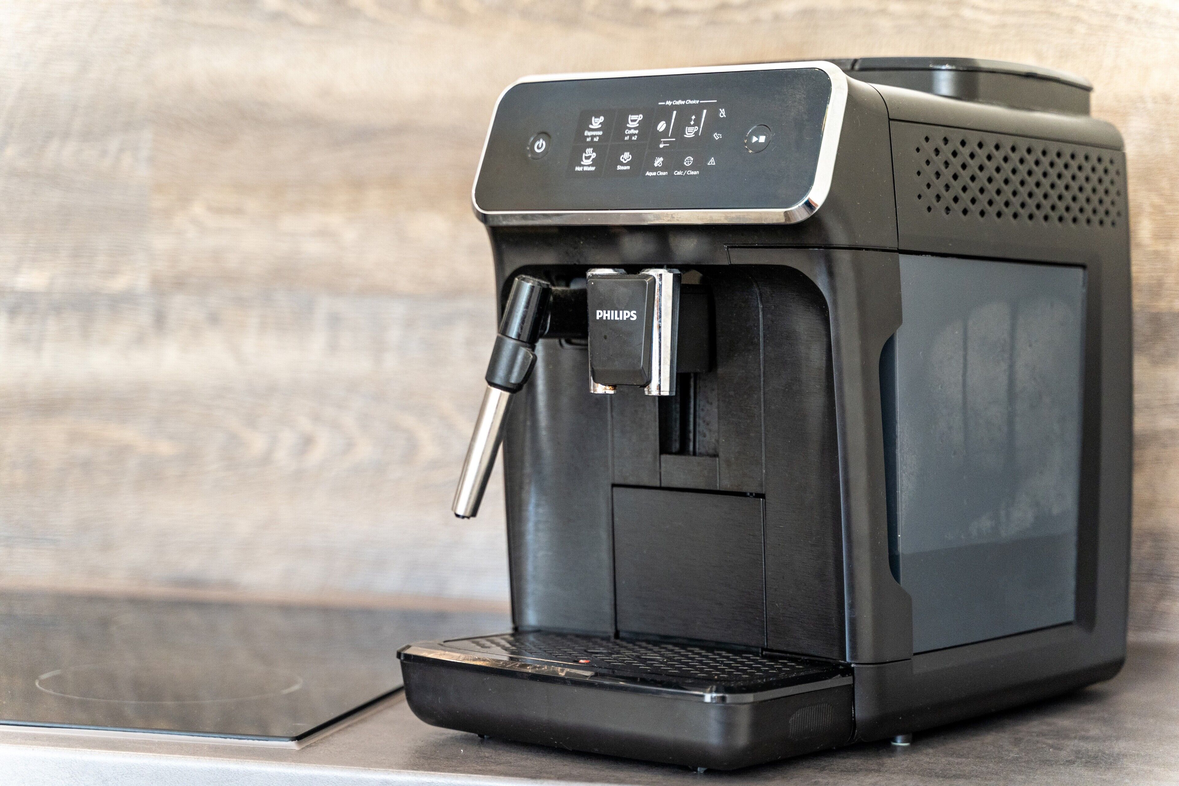 A coffee machine with a digital display, a water reservoir, and a drip tray.