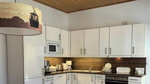 Eine moderne Küche mit weißen Schränken, einer Holz Arbeitsplatte und einem eingebauten Backofen.