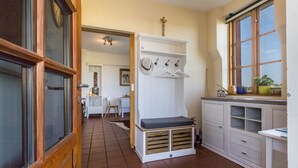 Une cuisine compacte dotée d’une banquette intégrée, d’un meuble blanc et d’une fenêtre offrant une belle vue.