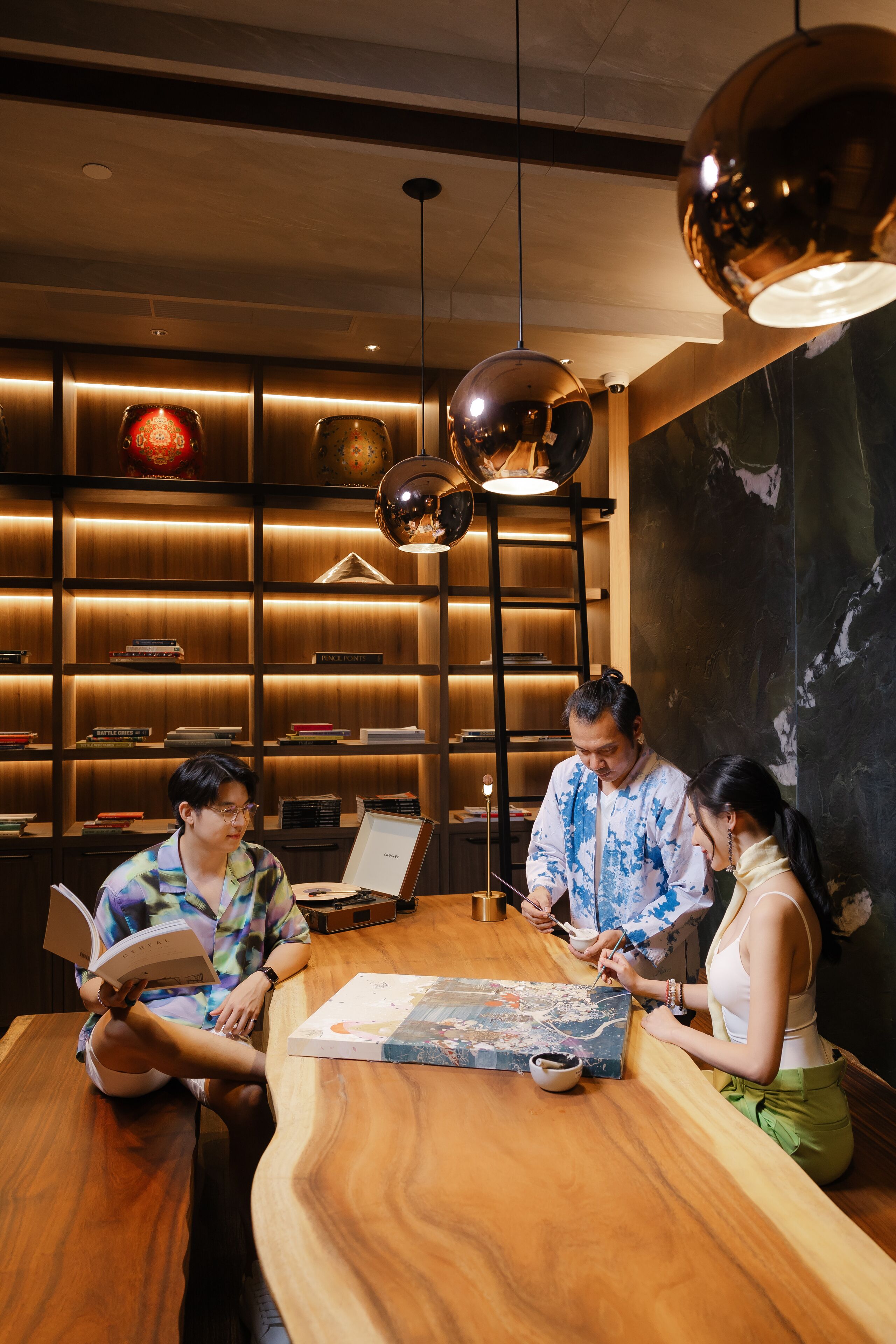 A modern interior with a wooden reception desk, a globe map, and a bookshelf with books and decorative items.