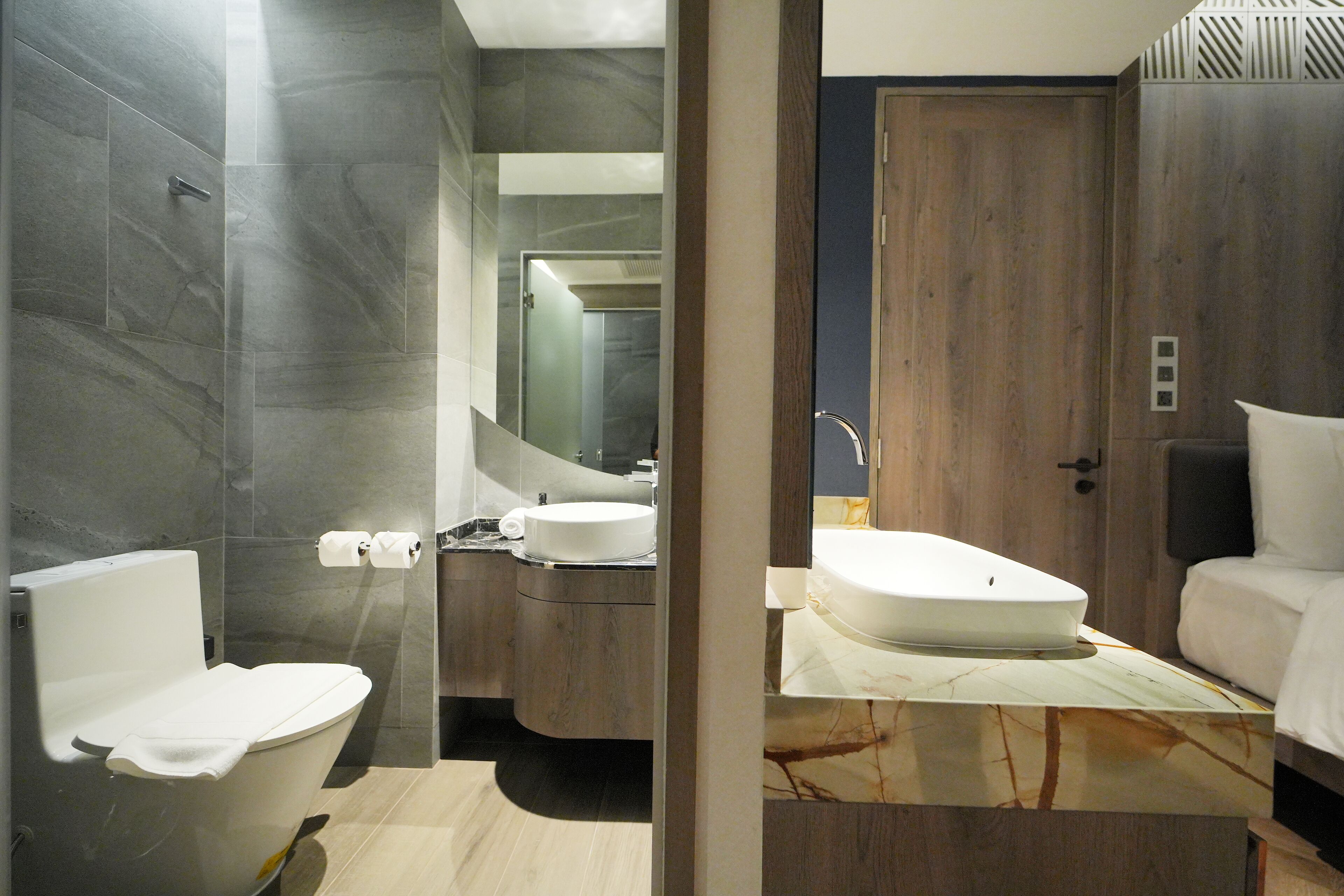 A modern bathroom with a toilet, sink, and mirror.