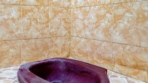 A bathroom with a marble-tiled wall and a purple bidet. - Hotel O Anisah Adil Homestay SyariahNearsmart Kampung Desa Pakistaji (Banyuwangi)