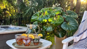 Eine Terrassenanlage mit einem Tisch für zwei Personen, mit zwei Gläsern Eistee, verziert mit Zitronenscheiben, und einer Wasserkanne.