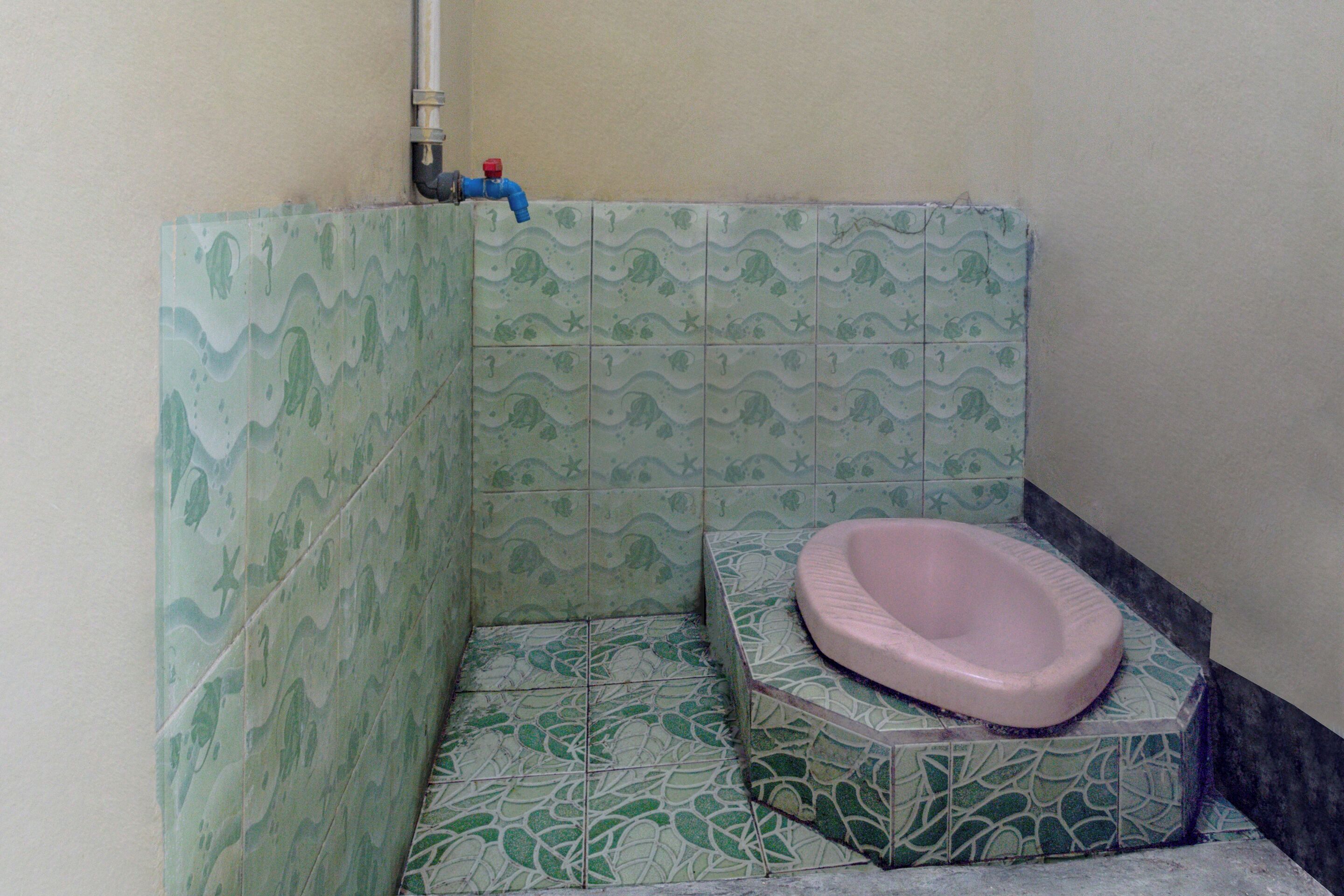 A bathroom with a toilet, a sink, and a shower area.