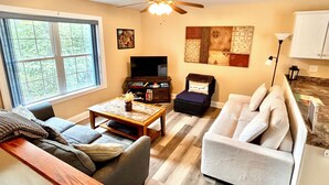 A living room with a sofa, armchair, coffee table, and a television. - Family & pet-friendly, peaceful rural escape. Hiking nearby. (Harding)