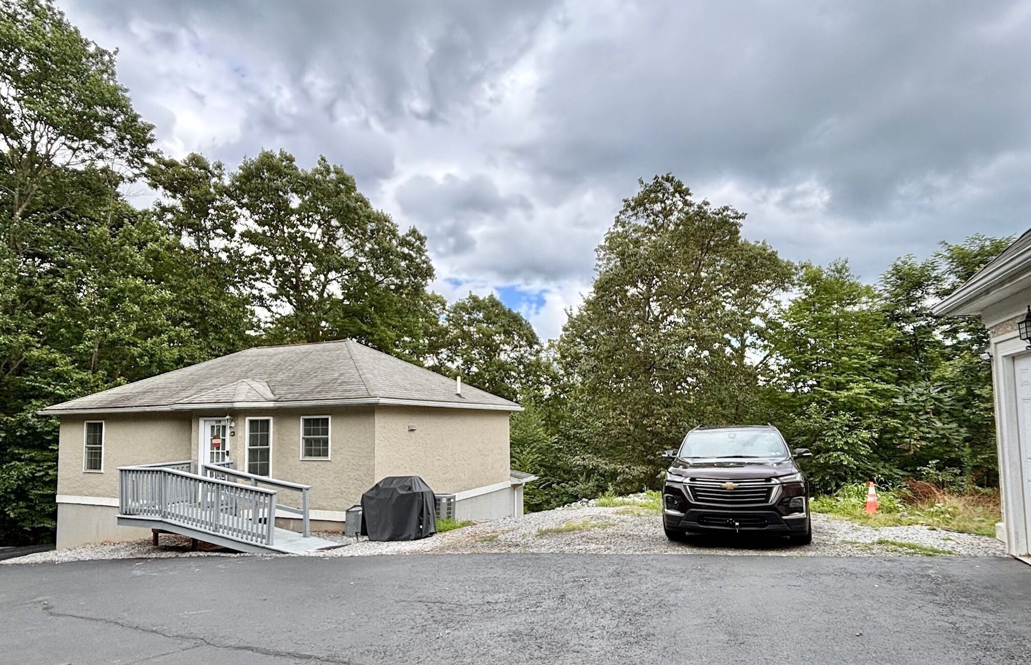A two-story house with a covered garage, a covered carport, and a driveway.