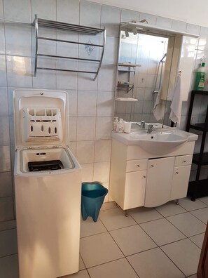 Chuveiro, toalhas de banho, sabonete, shampoo