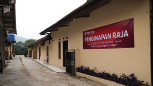 A building with a large red banner advertising Penginapan Raja. - Hotel O Penginapan Raja (Sukabumi)