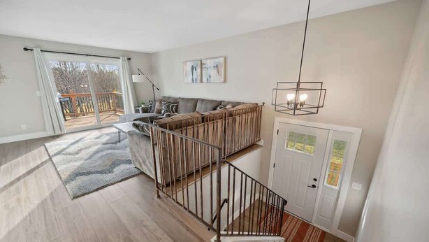 Un appartement moderne doté d’un escalier, d’un ensemble de canapés et d’un coin repas.