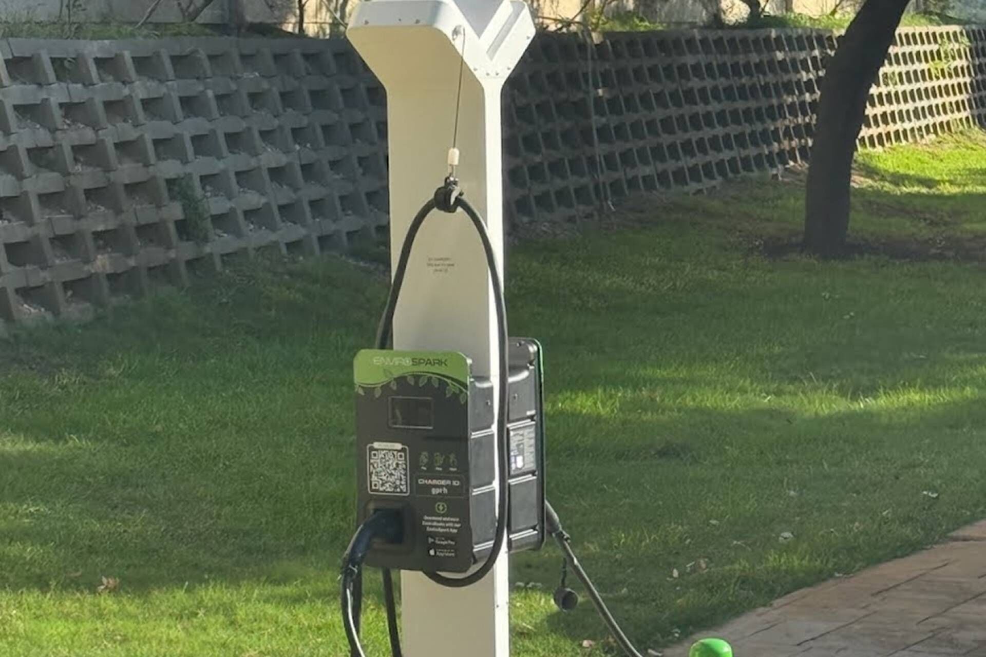 Eine öffentliche Ladestation für Elektroautos mit einem QR-Code und Bedienungsanleitung.