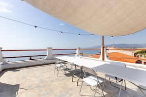 A terrace with a table and chairs, a view of the sea, and a clear sky. - Holiday Home 'Casa Simo' with Sea View, Wi-Fi and Air Conditioning (Porto Alabe)