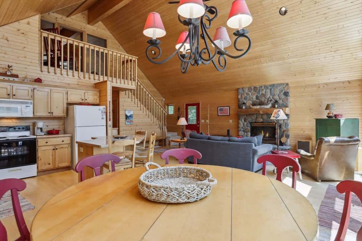 Un'ampia baita in legno con cucina, zona pranzo e soggiorno.