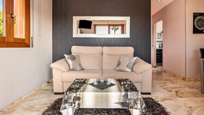 A modern living room with a sofa, a coffee table, and a framed picture on the wall.