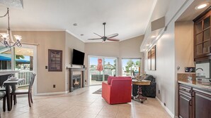 A spacious living room with a fireplace, a red sofa, and a dining area with a table and chairs. - Lakefront Gem • Boat Rental • Sleeps 8 people (Discovery Bay)
