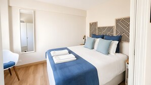 A bedroom with a bed, a chair, a wardrobe, and a mirror. - Lovely & Comfy 3 – Apartment near the beach in Estoril for up to 4 guests (Estoril)