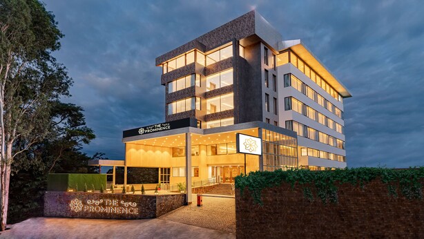 A modern hotel with a prominent entrance, multiple floors, and a well-lit facade. - The Prominence Hotel (Dehradun)
