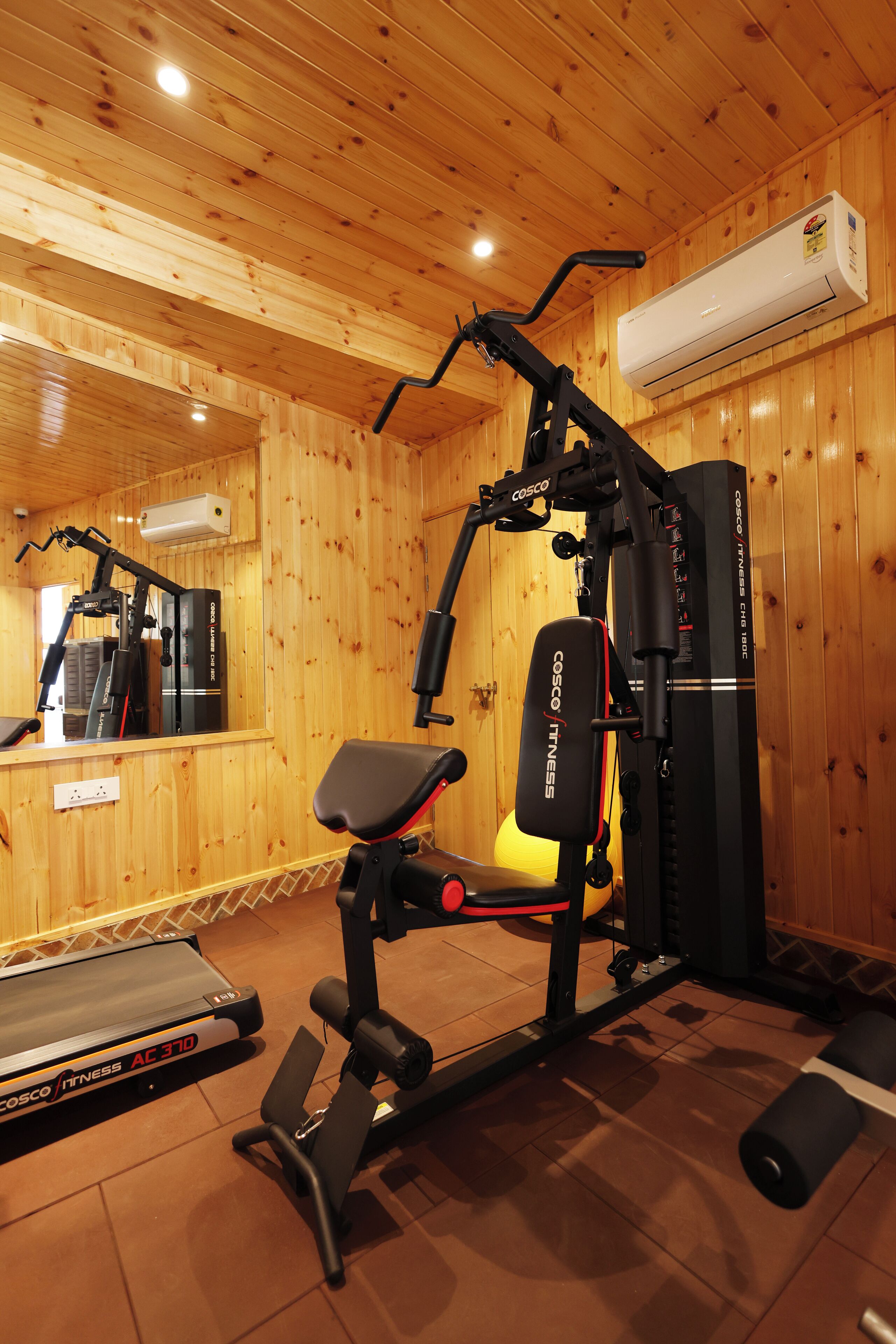 A gym with a treadmill, a stationary bike, and a weight bench.