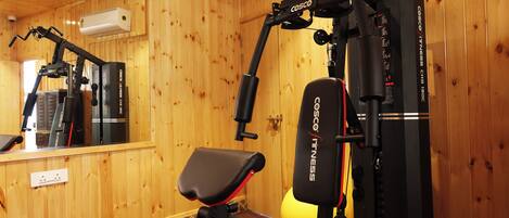 A gym with a treadmill, a stationary bike, and a weight bench.