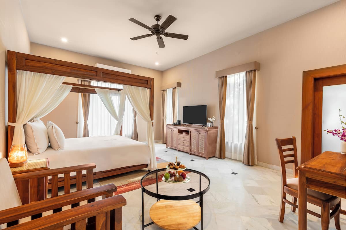 Une chambre à coucher avec un lit, une table de chevet et un ventilateur de plafond.