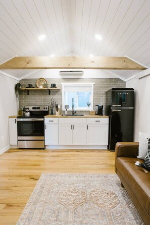 A modern kitchen with a built-in oven, a refrigerator, and a window above the sink. - Beautiful Getaway with Hot Tub (Spearfish)