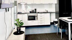 Una cocina moderna con armarios blancos, encimera negra y un comedor con mesa y sillas.