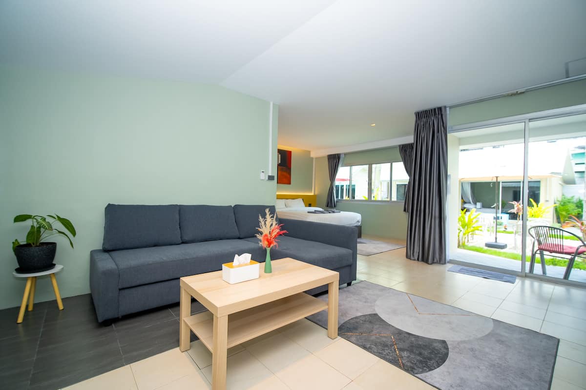A modern living room with a grey sofa, a wooden coffee table, and a potted plant.