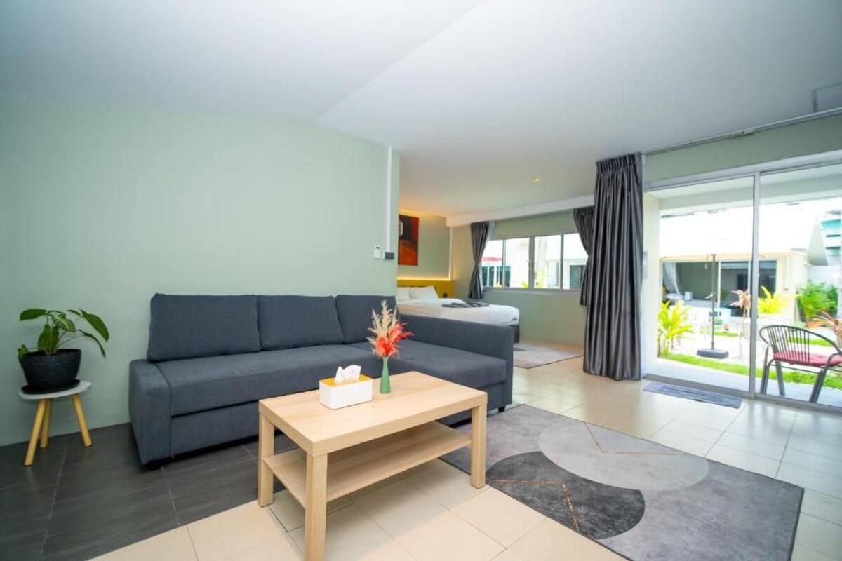 A modern living room with a grey sofa, a wooden coffee table, and a potted plant.