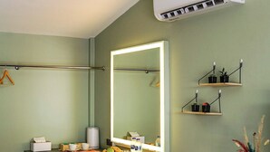 A bathroom with a large mirror, a towel rack, a sink, and a small stool. - Maiiam Bungalows (Karon)