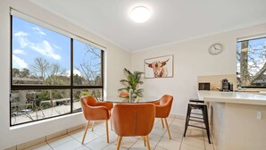 Una cocina moderna con comedor, ventanas amplias y vistas al exterior.