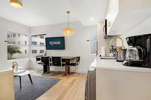 Enjoy a compact living space with a kitchenette, dining area, and large window offering a view of the outside.