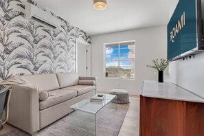 Relax in this stylish living room with a sofa, coffee table, and TV, offering a view of the outdoors.