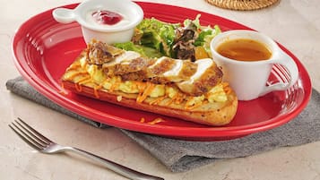 A breakfast plate with toast, scrambled eggs, and a side salad, accompanied by a cup of coffee and a small bowl of jam.
