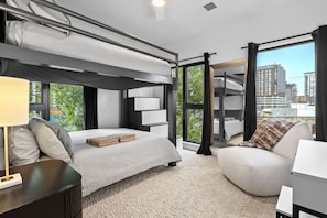 Relax in this stylish room with a bunk bed and single bed, a comfortable armchair, and a large window offering a city view.