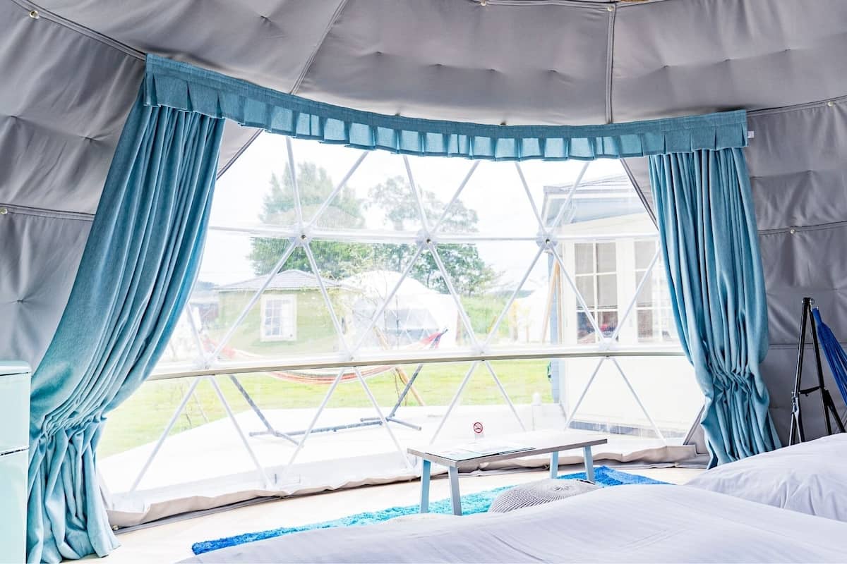 A tent-style room with a bed, a table, and a hammock.
