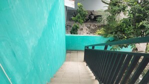 Eine Treppe mit einer türkisblauen Wand und einem schwarzen Geländer.