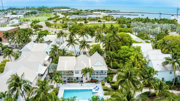 Un resort con varias construcciones, una piscina y vistas al océano.