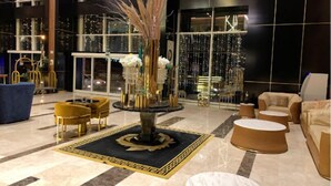 A lobby with a central fountain, seating areas, and large windows. - RODINA (Oran)