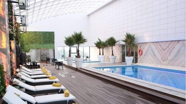A poolside area with lounge chairs and a pool. - RODINA (Oran)