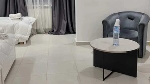 A hotel room with a bed, a round table with a bottle, and a chair. - Medina Park Hotel (Algiers)