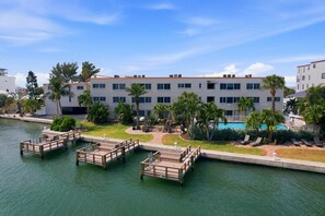 A waterfront hotel with a pool, docked boats, and a tropical garden. - Your Treasure Awaits! Sandy Beach + Bay & Pool! (Treasure Island)