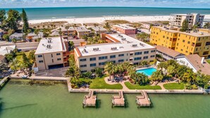 Un hôtel doté d’une piscine, de plusieurs bâtiments et situé en bord de mer.