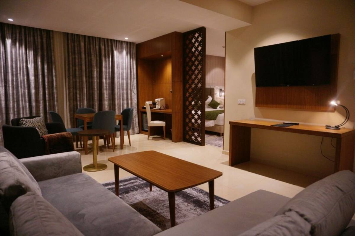 A modern living room with a sofa, coffee table, and a TV mounted on the wall.
