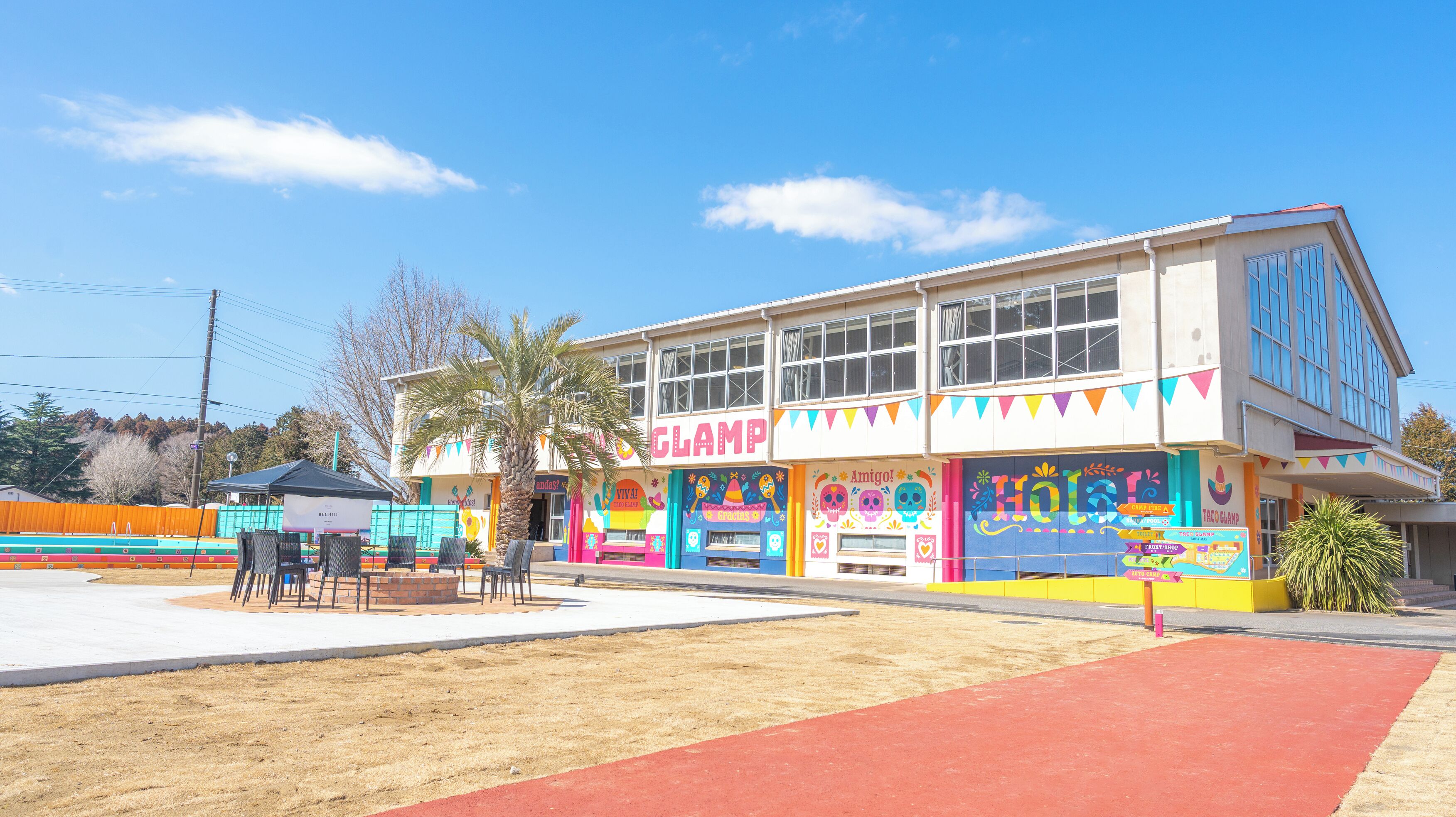 A colorful building with a 'CLAMP' sign, a palm tree, and outdoor seating.