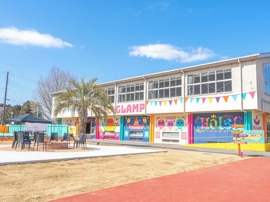 A colorful building with a 'CLAMP' sign, a palm tree, and outdoor seating.