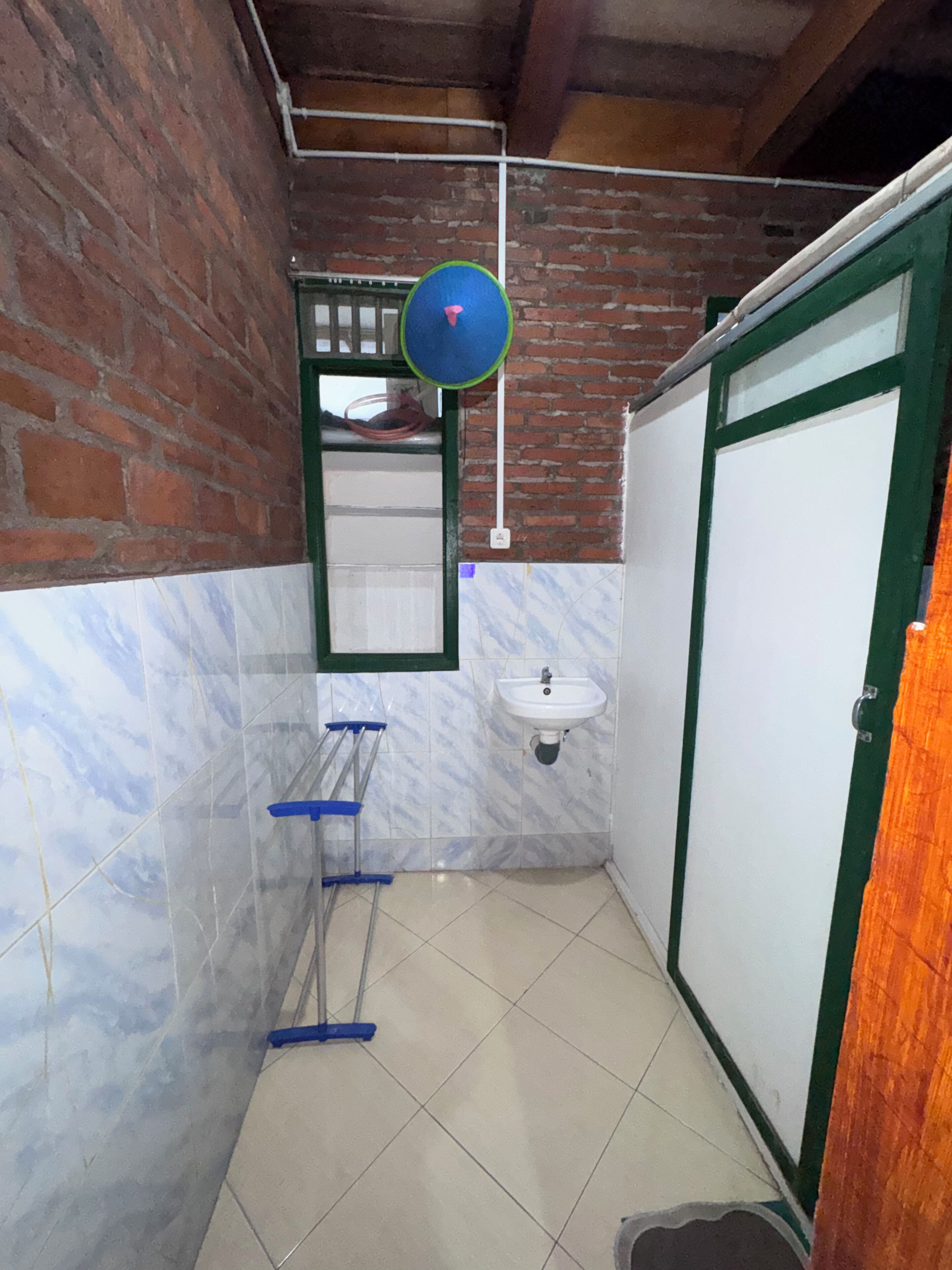 A bathroom with a sink, a mirror, a towel rack, and a door.