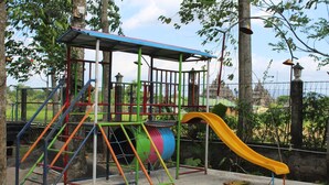 Une aire de jeux avec un toboggan, des structures d’escalade et un espace de jeux abrité.
