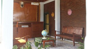 Un espace d’accueil avec un lambris en bois, un globe terrestre posé sur une table et un banc.